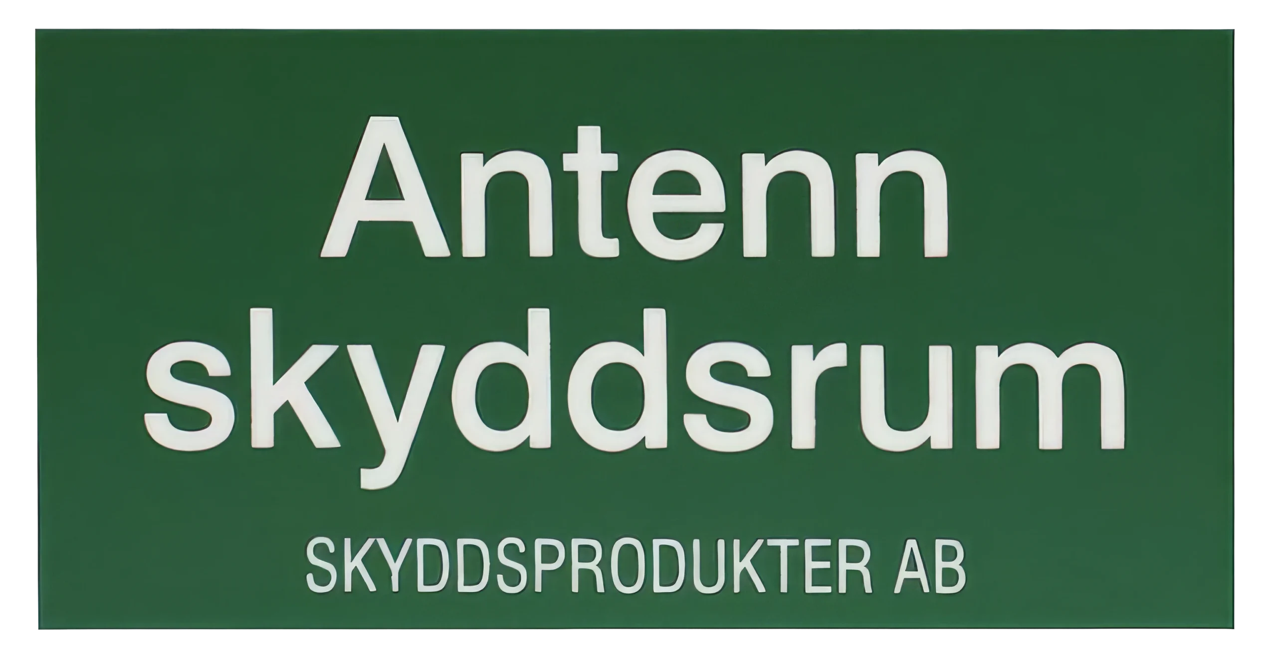 En grön skylt med vit text på svenska där det står "Antenn skyddsrum" och "SKYDDSPRODUKTER AB.