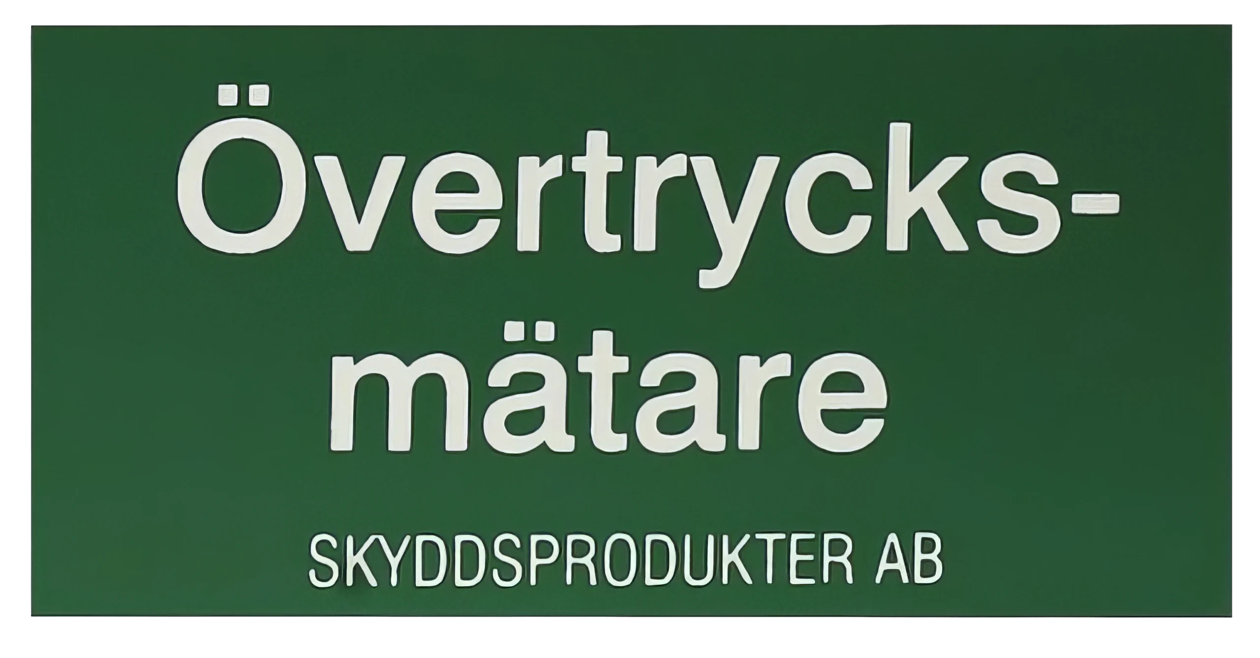 En grön skylt med vit text på svenska där det står ”Övertrycksmätare” och ”SKYDDSPRODUKTER AB”.